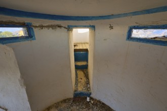 View from a worn round room with blue window frames into a dirty corridor, Lost Place, Lago