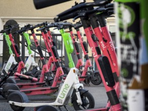 Many rental e-scooters parked on a pavement in Wuppertal, Germany