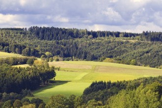 Wide landscape with green fields, hills and forests under partly sunny skies, Kreuztal, Siegerland