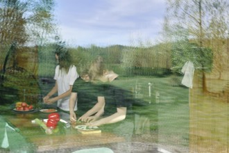 The view through the window to the kitchen, where the family is preparing a light snack. The glass