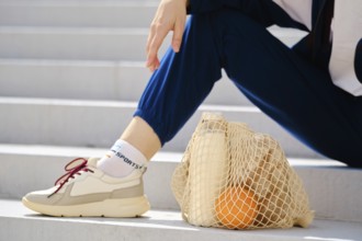 Essential food in reusable string bag on a stairs. Healthy living concept
