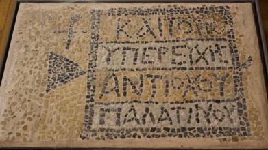 Ancient mosaic with ancient inscription and geometric patterns made of small stones, Archaeological