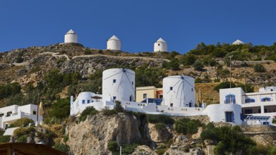 White windmills and buildings on a rocky slope of a Greek island, Pandeli Castle, Castle, Leros
