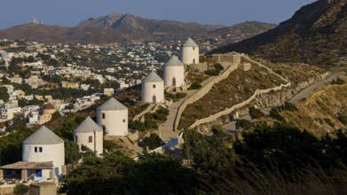 Row of windmills overlooking village, nestled in hilly landscape, Pandeli Castle, Castle, Leros