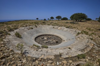Large concrete crater in an open, rocky landscape under a clear sky, Lost Place, Air Defence
