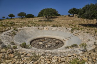 Round crater in a barren landscape with some trees on the horizon, Lost Place, Air Defence