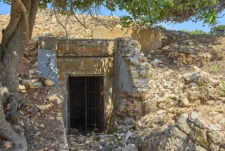 Closed ruin made of stone next to a tree in a sunny landscape, Lost Place, Air Defence Position,
