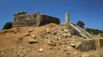 Old, crumbling structure on a desert-like terrain with rubble, Lost Place, Air Defence Position,