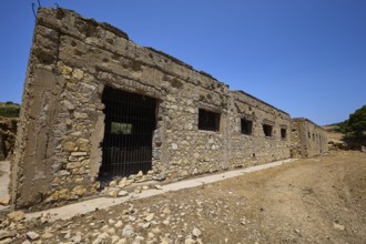 Stone building with several windows in a dry environment under a blue sky, Lost Place, Air Defence