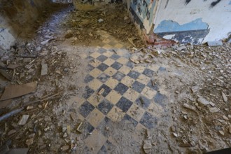 Lost Place, chequered pattern on the floor of a dilapidated room, surrounded by rubble and blue