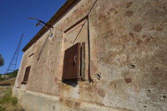 Lost Place, Old, peeling facade of a building with closed steel doors, Radio Station, WW2, Agios