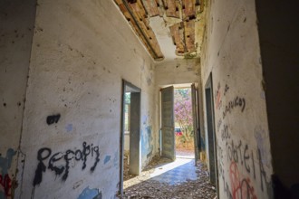 Lost Place, Abandoned hallway with graffiti and open doors, Flooded with light in a dilapidated