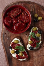 Sandwich with cream cheese, dried tomatoes, olives, breakfast, top view