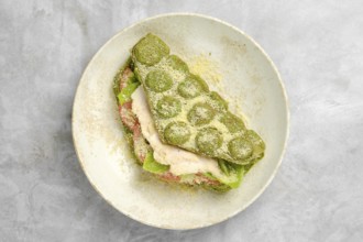 A vibrant green wrap is layered with fresh lettuce, slices of tomato, and tender chicken, resting