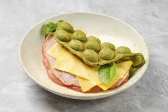 A unique green wrap made from a blend of ingredients encases layers of ham, cheese and spinach