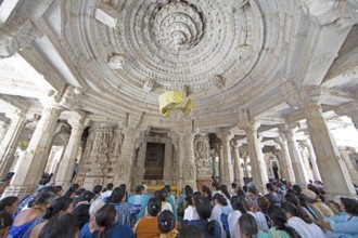 Indian woman praying between the white marble pillars in the Adinath temple in Ranakpur, Jain