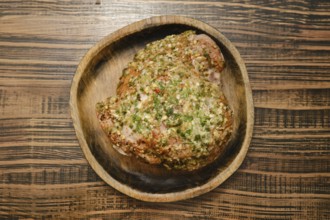 A flavorful turkey thigh is beautifully seasoned with a blend of aromatic herbs, displayed on a