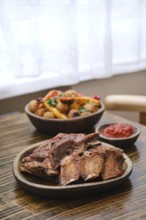 Succulent short beef ribs are freshly roasted in the oven, presented on a rustic plate