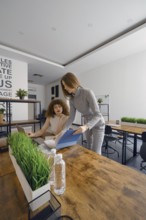 Two women engage in a productive discussion about a project in a contemporary office space