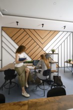 Two women discussing their a startup in the field of women's health in a contemporary office