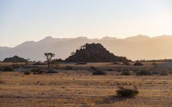 Desert landscape in the evening light at sunset, barren landscape with hills of stacked rocks,