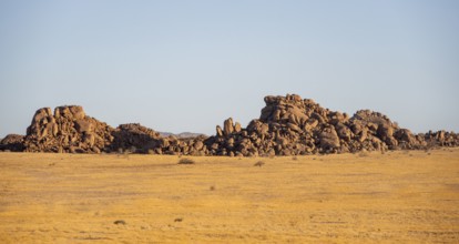 Barren landscape with hills of stacked rocks, desert landscape in the evening light at sunset,