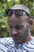 Young man with beard and sunglasses on forehead, Germany