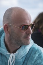 Portrait of a young man with sunglasses and fluffy jacket, Baden-Württemberg, Germany