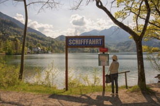 Lake Kochel, tourist reads the navigation map, Kochel, Upper Bavaria, Bavaria