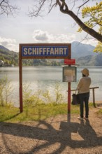 Lake Kochel, tourist reads the navigation map, Kochel, Upper Bavaria, Bavaria
