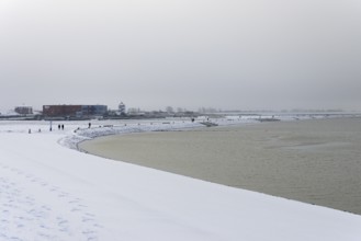 Winter day, onset of winter, snow on the North Sea coast, snow-covered beach promenade of