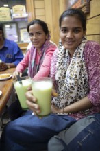 Indian woman drinking lassi or yoghurt drinks in a shop at Sandar Market Girdikot, old town of