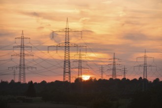 Power lines towering into the evening sky during a sunset, Waiblingen, Baden-Württemberg, Germany