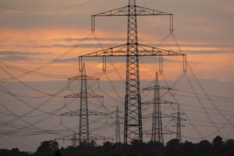 Close-up of electricity pylons against a brilliant orange evening sky, Waiblingen,