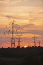 Dramatic silhouettes of electricity pylons against a colourful sky, Waiblingen, Baden-Württemberg,
