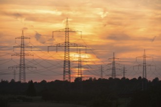 Sunset with electricity pylons and orange sky in a rural setting, Waiblingen, Baden-Württemberg,