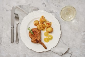 A delicious roasted pork rib roast is plated alongside golden, seasoned potatoes. The dish is