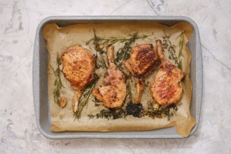 Juicy pork rib roasts are seasoned and cooked to perfection on a baking tray lined with parchment