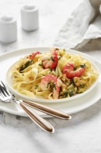 A delectable portion of fettuccine allo scoglio sits elegantly on a white plate. The dish features