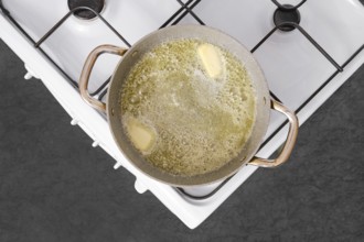 A pot on a stove is filled with melted butter, bubbling as it simmers. This is the starting point