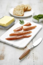 A platter features salted herring caviar arranged neatly alongside slices of bread and a portion of