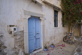 Ifestou Alley, A rustic blue-coloured door in an old wall surrounded by flowers, Kos Town, Kos,