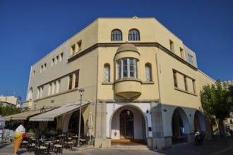 Town hall, backside, yellow historical building with arched windows, outside tables and chairs,