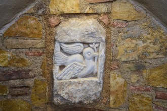 Ifestou Alley, Detailed stone sculpture of a dove with an olive branch in a wall, Kos Town, Kos,