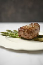 Succulent filet mignon is perfectly cooked and garnished with a sprinkle of sea salt, placed on a