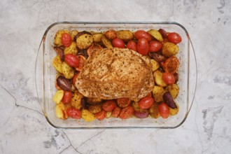 Juicy turkey breast seasoned with spices rests atop a bed of roasted baby potatoes, cherry