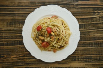 A generous serving of spaghetti topped with an assortment of seafood, including shrimp and mussels,