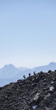 Hikers against the light on a ridge, Stubai Alps, South Tyrol, Italy