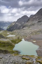 View of the turquoise-blue mountain lake Großer Gradensee, with the peaks of Petzeck and