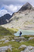 Hiker on the way to the Adolf Nossberger Hut, view of the turquoise-blue mountain lake Großer